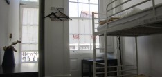 Dormitório feminino de 2 camas com casa de banho partilhada e varanda