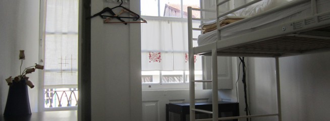 Dormitório feminino de 2 camas com casa de banho partilhada e varanda